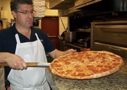 the owner with a good looking pizza